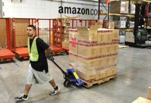 An Amazon worker in Phoenix, Arizona, wheels a dolly with boxes.
