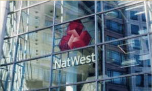 NatWest logo, which looks like three red boxes that form a triangle of sorts, is on what appears to be the window of a high rise.