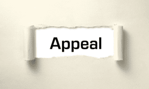 The word "appeal" on a piece of paper that is being ripped open.