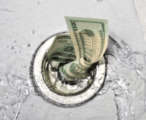 A picture of a $20 bill twirling down the drain.
