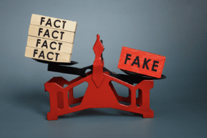 An image of a red tool holding a stack of three "Fact" blocks and one "Fake" block. 