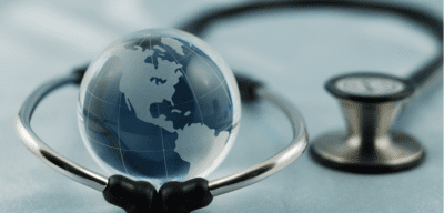 A stethoscope is wrapped around a globe.